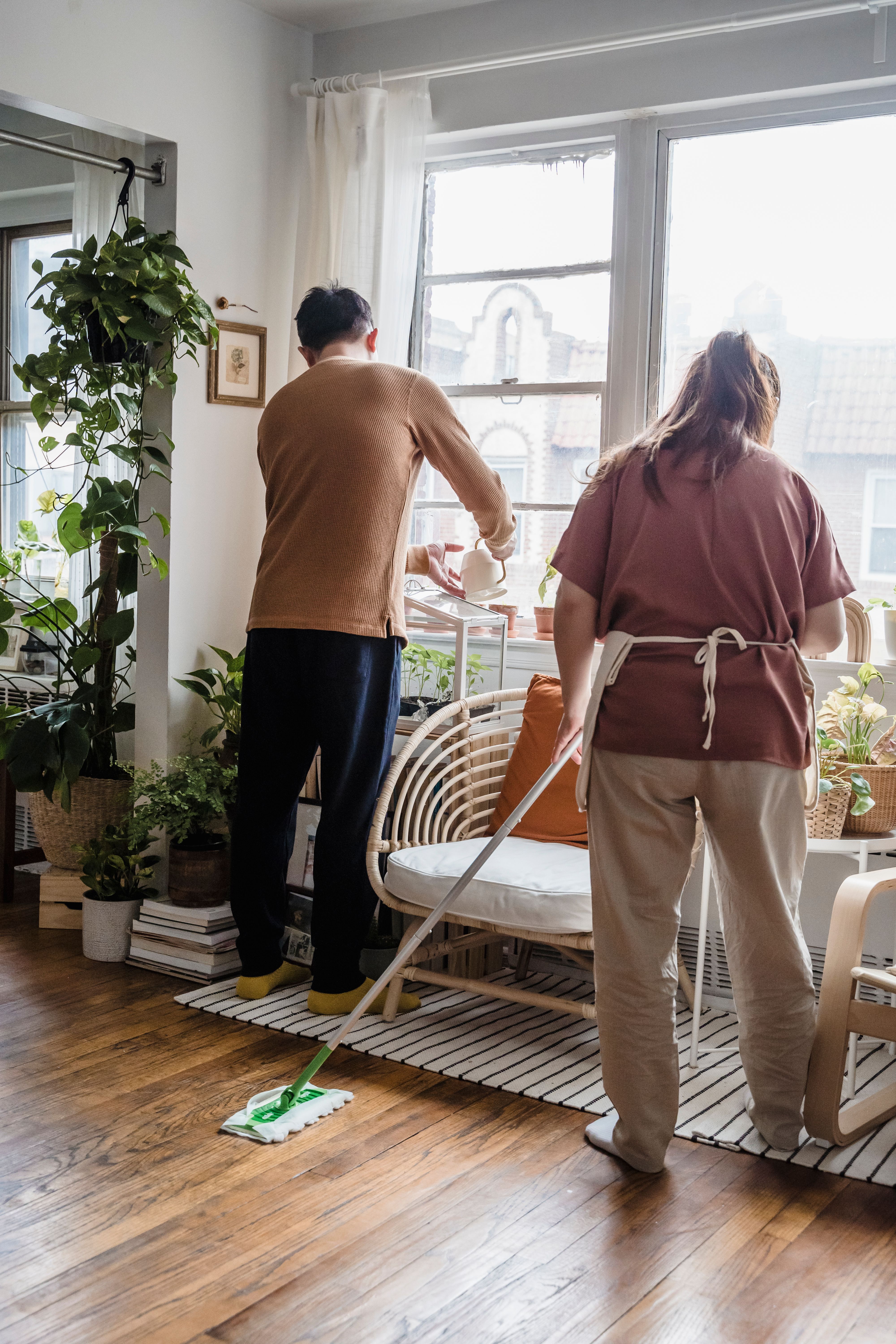 Two people cleaning a living room together